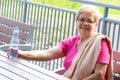 Senior woman sitting on bench, drinking water and resting after exercise or running, healthy lifestyle Royalty Free Stock Photo