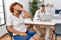 Senior woman sitting at doctor appointment smiling and laughing with hand on face covering eyes for surprise Royalty Free Stock Photo