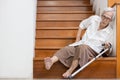 Senior woman sitting on the floor of the staircase with pain in hips and back,tripped or lose balance as she walked downstairs