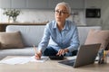 senior woman sitting with laptop and taking notes at home Royalty Free Stock Photo