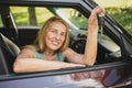 Senior woman sitting in new car outdoors holding keys, smiling, enjoying journey. Driving courses and life insurance Royalty Free Stock Photo