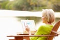 Senior Woman Sitting At Outdoor Table Painting Landscape Royalty Free Stock Photo