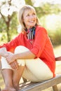 Senior Woman Sitting Outdoors On Bench Royalty Free Stock Photo