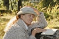 Senior woman sitting outdoors reading a book Royalty Free Stock Photo