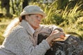 Senior woman sitting outdoors reading a book Royalty Free Stock Photo