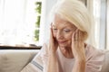 Senior Woman Sitting On Sofa At Home Suffering From Depression Royalty Free Stock Photo