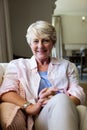 Senior woman sitting on sofa in living room Royalty Free Stock Photo