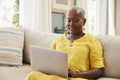 Senior Woman Sitting On Sofa Using Laptop At Home Together Royalty Free Stock Photo