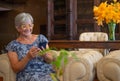 Senior woman sitting on sofa using mobile phone, Smiling modern retiree enjoying relaxing moment