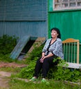 A senior woman sitting tired near her house in the village Royalty Free Stock Photo