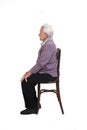 Senior woman sitting on white background