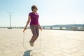 Senior woman with skipping rope doing practice in a public park in the center of town. Royalty Free Stock Photo