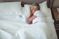 Senior woman sleeping on bed in bedroom Royalty Free Stock Photo