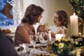 Senior woman with small granddaughter indoors at Christmas.