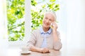 Senior woman with smartphone calling at home Royalty Free Stock Photo