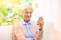 Senior woman with smartphone and earphones at home Royalty Free Stock Photo