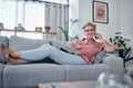 Senior woman, sofa and phone call in home living room with smile, relax and newspaper for happy portrait. Retirement Royalty Free Stock Photo
