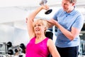 Senior woman at sport exercise in gym with trainer Royalty Free Stock Photo