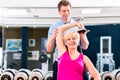 Senior woman at sport exercise in gym with trainer Royalty Free Stock Photo