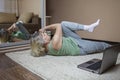 Senior woman in sportswear watching online video on laptop and doing fitness exercises at home Royalty Free Stock Photo