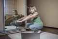 Senior woman in sportswear watching online video on laptop and doing fitness exercises at home Royalty Free Stock Photo