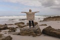 Senior woman standing with arms outstretched on the rock at beach Royalty Free Stock Photo