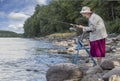 A senior woman standing with her walker by the lake and fishing Royalty Free Stock Photo