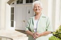 Senior woman standing outside house