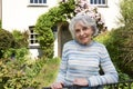 Senior Woman Standing Outside Pretty Cottage Royalty Free Stock Photo