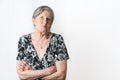 Senior woman sticks out her tongue on a mocking face while looking at camera on white background studio shot Royalty Free Stock Photo