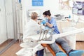 Senior woman stomatologist analyzing teeth of sick patient