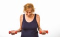 Senior Woman Straining To Lift Two Small Dumbbells