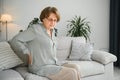 Senior woman suffering from back pain on sofa at home Royalty Free Stock Photo