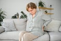 Senior woman suffering from back pain on sofa at home Royalty Free Stock Photo