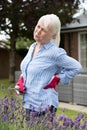Senior Woman Suffering From Backache Whilst Gardening At Home