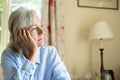 Senior Woman Suffering With Depression Looking Out Of Window At Home Royalty Free Stock Photo