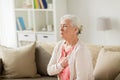 Senior woman suffering from heartache at home