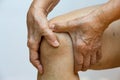 Senior woman suffering from right knee pain, Massaging by her hand in white background, Close up & Macro shot, Asian body skin Royalty Free Stock Photo