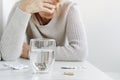 Senior woman suffering and taking pills from migraine. Headache treatment