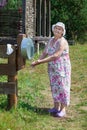 Senior woman in summer dress washing hands in country residence Royalty Free Stock Photo