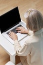 Senior woman surfing the net on laptop at home Royalty Free Stock Photo