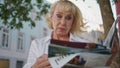 Senior woman surprised news in magazine outdoors close up. Old lady reading Royalty Free Stock Photo