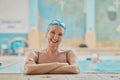 Senior woman, swimmer in water and relax in swimming pool of hotel resort for healthy elderly exercise, swim training Royalty Free Stock Photo