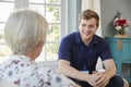 Senior woman talking with male care worker on home visit Royalty Free Stock Photo