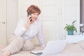 Senior woman talking on mobile phone, sitting on the bed at home. Happy retired person shopping online Royalty Free Stock Photo