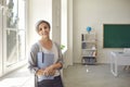 Senior woman teacher with gray hair smiling while standing in a university school class Royalty Free Stock Photo