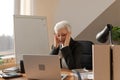 Senior woman touching temples experiencing stress in office. Mature lady tired of working feeling headache sick rubbing Royalty Free Stock Photo