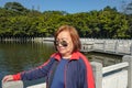 Senior women tourist stand beside the Lake on top of the xiqiao mountain foshan city china