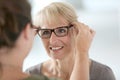 Senior woman trying on eyeglasses