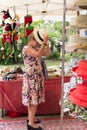 Senior woman trying on a hat at Eumundi markets, Queensland, Australia